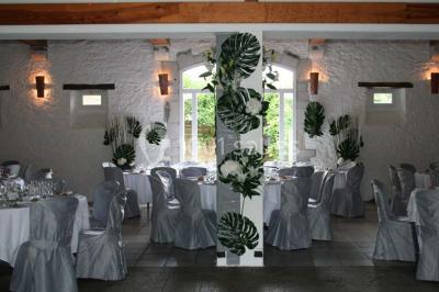 Cuisine professionnelle avec plans de travail en inox, hotte d'extraction, évier et carrelage mural blanc.