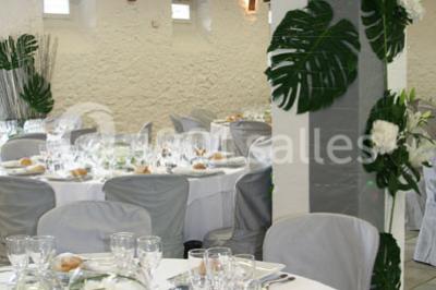 Cuisine professionnelle avec plans de travail en inox, hotte d'extraction, évier et carrelage mural blanc.