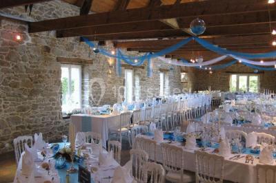 Allée ombragée avec banc en bois, hortensias en fleurs et panneaux directionnels près d'un arbre.
