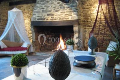 Allée ombragée avec banc en bois, hortensias en fleurs et panneaux directionnels près d'un arbre.