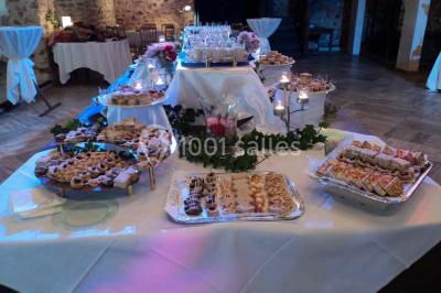 Grand jardin avec pelouse, arbres alignés et une structure couverte avec des tables et chaises blanches.