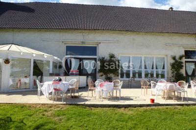 Salle voûtée en pierre avec éclairage rouge, tables basses, poufs et narguilés disposés dans une ambiance orientale.