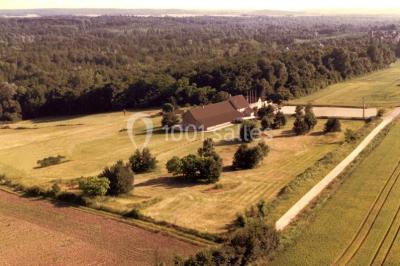 Salle voûtée en pierre avec éclairage rouge, tables basses, poufs et narguilés disposés dans une ambiance orientale.