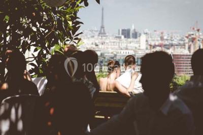 Salle de réception éclairée par des lumières violettes, avec un bar et des tables dans un décor chaleureux.