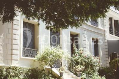 Salle de réception éclairée par des lumières violettes, avec un bar et des tables dans un décor chaleureux.