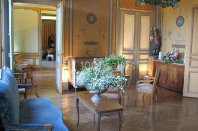 Salle de réception éclairée par des lumières violettes, avec un bar et des tables dans un décor chaleureux.