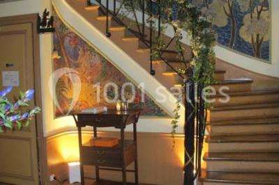 Salle de réception éclairée par des lumières violettes, avec un bar et des tables dans un décor chaleureux.