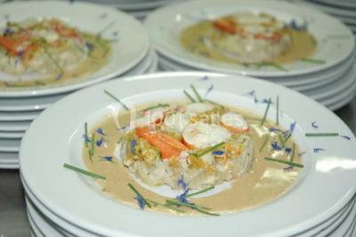 Salle de réception éclairée par des lumières violettes, avec un bar et des tables dans un décor chaleureux.