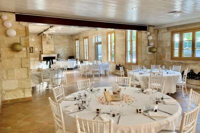 Salle à manger élégante avec table dressée, bouquet de fleurs au centre, grande fenêtre ouverte sur un jardin verdoyant.