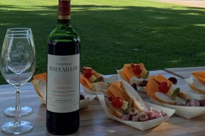 Salle à manger élégante avec table dressée, bouquet de fleurs au centre, grande fenêtre ouverte sur un jardin verdoyant.