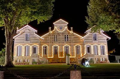 Salle à manger élégante avec table dressée, bouquet de fleurs au centre, grande fenêtre ouverte sur un jardin verdoyant.