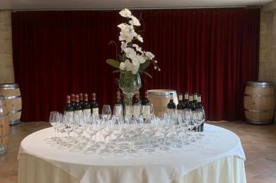 Salle à manger élégante avec table dressée, bouquet de fleurs au centre, grande fenêtre ouverte sur un jardin verdoyant.