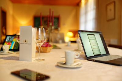 Salle à manger élégante avec table dressée, bouquet de fleurs au centre, grande fenêtre ouverte sur un jardin verdoyant.