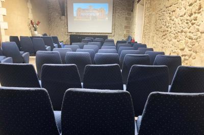 Salle à manger élégante avec table dressée, bouquet de fleurs au centre, grande fenêtre ouverte sur un jardin verdoyant.