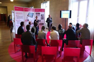 Pelouse avec des personnes assises ou allongées devant un grand bâtiment historique entouré d'arbres.