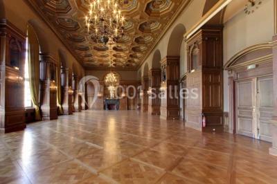 Pelouse avec des personnes assises ou allongées devant un grand bâtiment historique entouré d'arbres.