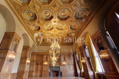 Pelouse avec des personnes assises ou allongées devant un grand bâtiment historique entouré d'arbres.