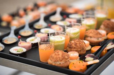 Plateaux de bouchées apéritives avec fromage, raisin, jambon et brochettes, accompagnés de verres de champagne en arrière…