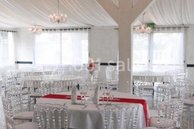 Bouées en forme de cygne et licorne flottant dans une piscine, avec des tentes blanches en arrière-plan.