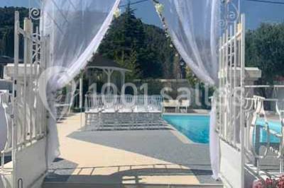 Bouées en forme de cygne et licorne flottant dans une piscine, avec des tentes blanches en arrière-plan.