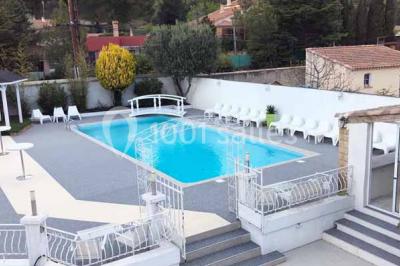 Bouées en forme de cygne et licorne flottant dans une piscine, avec des tentes blanches en arrière-plan.