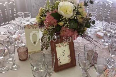 Bouées en forme de cygne et licorne flottant dans une piscine, avec des tentes blanches en arrière-plan.