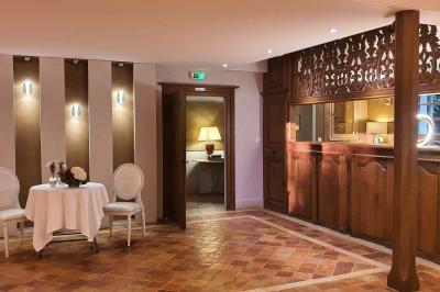 Couronne de fleurs blanches et roses suspendue à un arbre sous la lumière du soleil dans un jardin verdoyant.