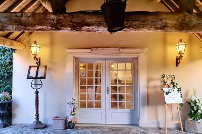 Couronne de fleurs blanches et roses suspendue à un arbre sous la lumière du soleil dans un jardin verdoyant.