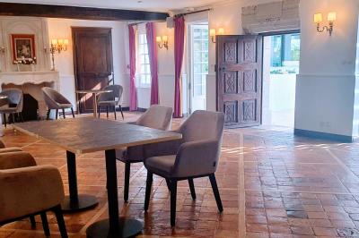 Couronne de fleurs blanches et roses suspendue à un arbre sous la lumière du soleil dans un jardin verdoyant.