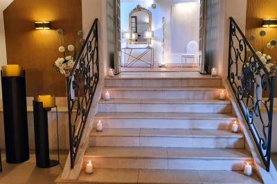 Couronne de fleurs blanches et roses suspendue à un arbre sous la lumière du soleil dans un jardin verdoyant.