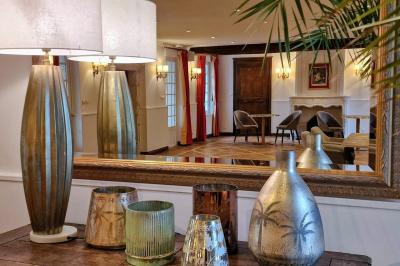 Couronne de fleurs blanches et roses suspendue à un arbre sous la lumière du soleil dans un jardin verdoyant.