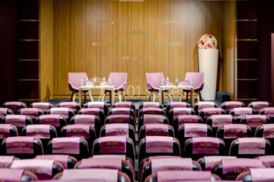 Bibliothèque avec étagères remplies de livres colorés, deux fauteuils jaunes et une table basse avec des livres ouverts.