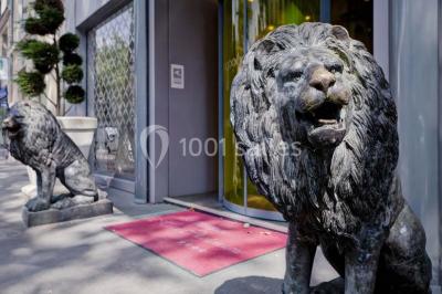 Bibliothèque avec étagères remplies de livres colorés, deux fauteuils jaunes et une table basse avec des livres ouverts.