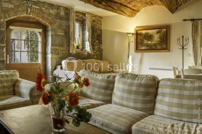 Chambre lumineuse avec deux lits simples, armoire ancienne, murs en bois et fenêtres donnant sur un jardin.