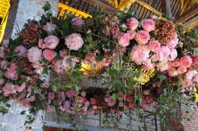 Chambre lumineuse avec deux lits simples, armoire ancienne, murs en bois et fenêtres donnant sur un jardin.