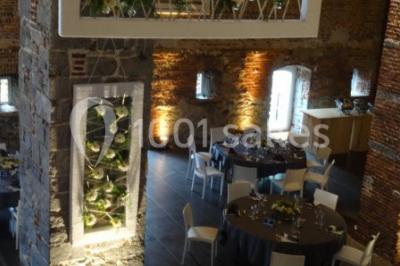 Chambre lumineuse avec deux lits simples, armoire ancienne, murs en bois et fenêtres donnant sur un jardin.