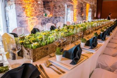 Chambre lumineuse avec deux lits simples, armoire ancienne, murs en bois et fenêtres donnant sur un jardin.