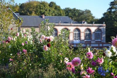 Salle de bain avec cabine de douche arrondie en verre, lavabo intégré dans un meuble en bois et carrelage beige.