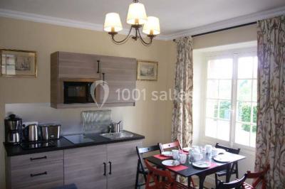 Salle de bain avec cabine de douche arrondie en verre, lavabo intégré dans un meuble en bois et carrelage beige.