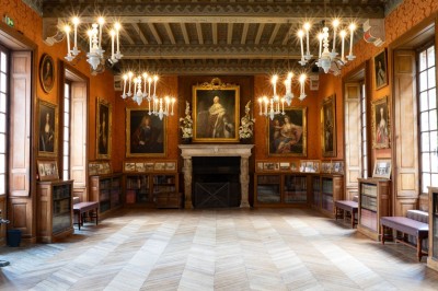 Miniature La grande Galerie Table dressée avec des assiettes, des plats de tartes et de desserts variés, dans une salle décorée de tableaux et de…