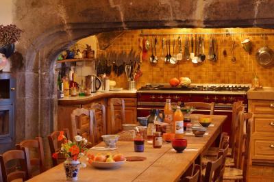 Chambre lumineuse avec lit double, canapé, meubles en bois, plafond avec poutres bleues et fenêtre donnant sur l'extérieur.
