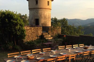 Chambre lumineuse avec lit double, canapé, meubles en bois, plafond avec poutres bleues et fenêtre donnant sur l'extérieur.