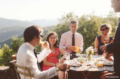 Chambre lumineuse avec lit double, canapé, meubles en bois, plafond avec poutres bleues et fenêtre donnant sur l'extérieur.