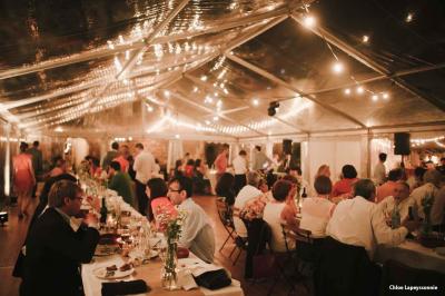 Chambre lumineuse avec lit double, canapé, meubles en bois, plafond avec poutres bleues et fenêtre donnant sur l'extérieur.