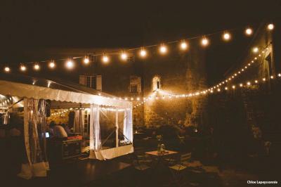 Chambre lumineuse avec lit double, canapé, meubles en bois, plafond avec poutres bleues et fenêtre donnant sur l'extérieur.
