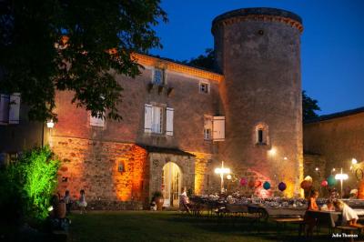 Chambre lumineuse avec lit double, canapé, meubles en bois, plafond avec poutres bleues et fenêtre donnant sur l'extérieur.