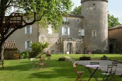 Chambre lumineuse avec lit double, canapé, meubles en bois, plafond avec poutres bleues et fenêtre donnant sur l'extérieur.