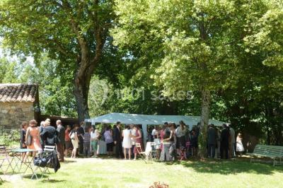 Chambre lumineuse avec lit double, canapé, meubles en bois, plafond avec poutres bleues et fenêtre donnant sur l'extérieur.