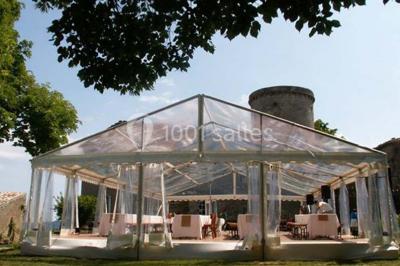Chambre lumineuse avec lit double, canapé, meubles en bois, plafond avec poutres bleues et fenêtre donnant sur l'extérieur.