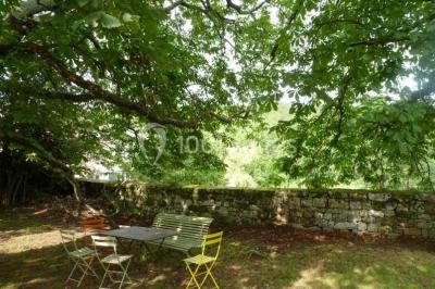 Chambre lumineuse avec lit double, canapé, meubles en bois, plafond avec poutres bleues et fenêtre donnant sur l'extérieur.